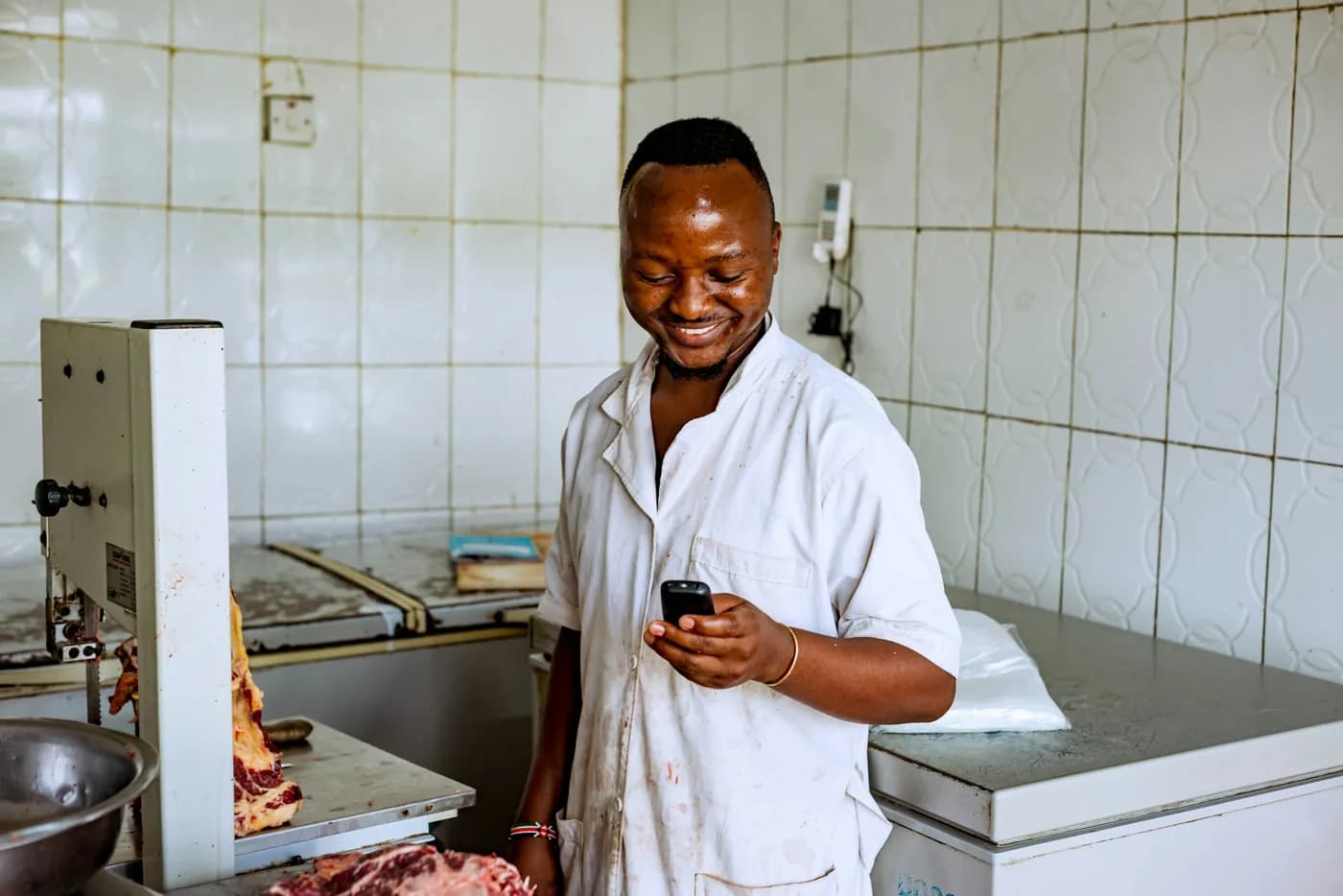 Butcher checking a payment on his phone