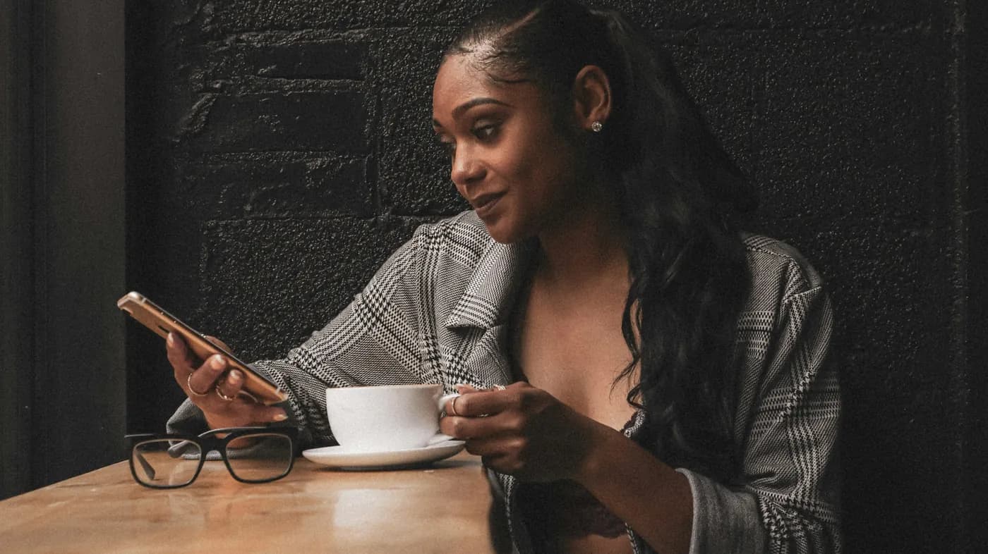 Customer confirming a payment prompt on her phone at a café