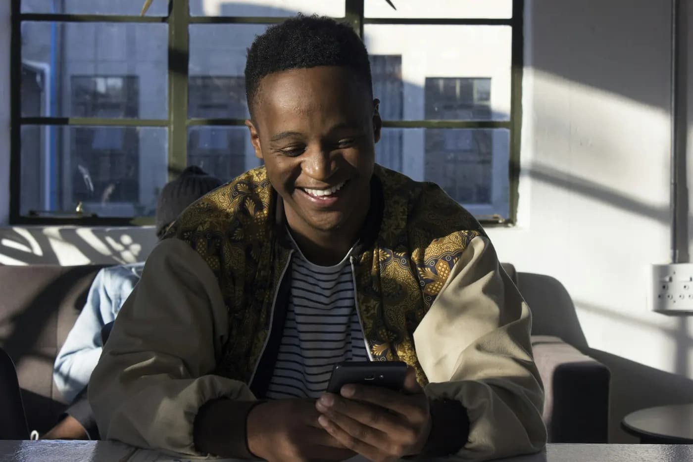 Young man smiling while using his phone