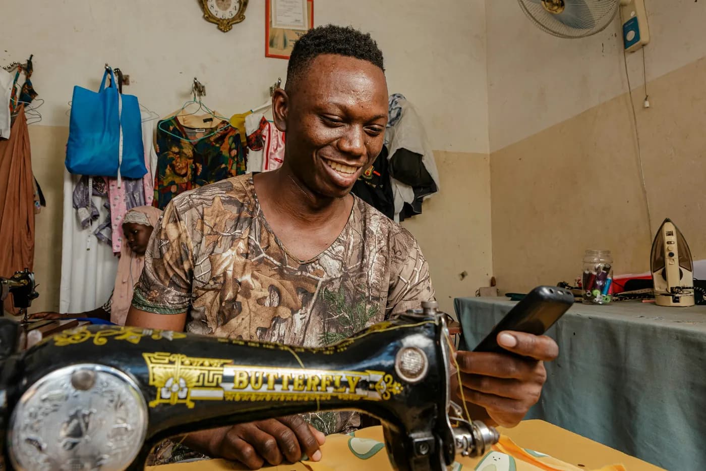Fundi cherehani wa kijijini akipokea malipo kwenye simu yake